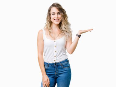 Neşeli sunulması ve kameraya bakarak avucunun ile işaret gülümseyen izole arka plan genç güzel sarışın kadın.