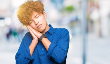 Uyku yorgun hayal ve eller ile birlikte kapalı gözlerle gülümseyerek poz afro saçlı Genç yakışıklı zarif adam.