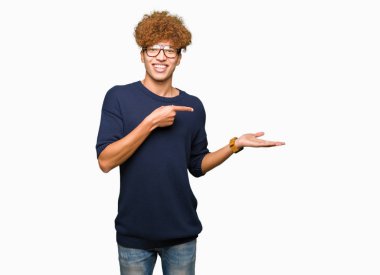 Afro hayrete ve el ile sunulması ve parmak ile işaret ederken kameraya gülümseyen gözlüklü genç yakışıklı adamla.