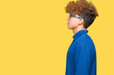 Afro saç ile genç yakışıklı adam yan arayan mavi gözlük giyiyor, güvenli bir gülümseme ile doğal yüzü ile profil poz rahatlayın.