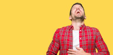 Rahat gömlek giyen yakışıklı adam gülümseyen ve zor dışarı yüksek sesle gülüyor Çünkü komik çılgın şaka. Mutlu ifade.