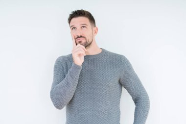 Genç yakışıklı adam, çene üzerinde el ile izole arka plan üzerinde rahat kazak giyen soru hakkında düşünme, dalgın ifade. Düşünceli bir yüz ile gülümsüyor. Şüphe kavramı.