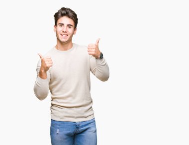 Yakışıklı delikanlı izole arka plan başarı işareti el ile pozitif jest yapıyor üzerinde başparmak gülümseyen ve mutlu. Neşeli bir ifadeyle, kazanan jest kameraya bakıyor.