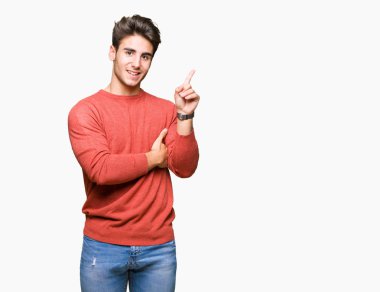 Kameraya bakarak yan el ve parmak ile işaret eden genç yakışıklı adam yüzünde kocaman bir gülümseme ile izole arka plan üzerinde.