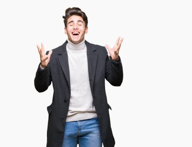 İzole arka plan üzerinde kış ceket giyen genç zarif adam deli ve silah ile başarı için deli kutluyor kaldırdı ve heyecanlı çığlık kapalı gözleri. Kazanan kavramı