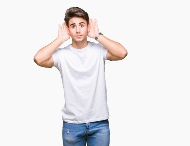 Her ikisi de dinliyoruz izole arka plan üzerinde beyaz t-shirt giyen genç yakışıklı adam kulak jest, dedikodu için meraklı eller. İşitme sorunu, sağır