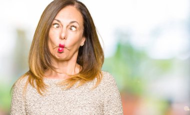 Moda kazak dudaklı, çılgın ve komik bir jest yapma balık yüz giyen güzel orta yaş kadın. Komik ifade.