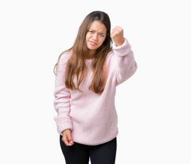 Öfkeli ve sinirli sinirli ve öfke ile bağırarak süre öfkeli yumruk yükselterek izole arka plan üzerinde pembe kış kazak giyen genç güzel esmer kadın. Öfke ve agresif kavramı.