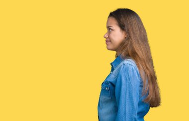 İzole arka tarafına, seyir üzerinde mavi kot gömlek giyen genç güzel esmer kadın dinlenmek doğal yüz emin gülümseme ile pozuyla profili.