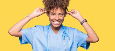 İzole arka plan gülen çekerek kulakları ile parmak, komik jest kadın genç Afro-Amerikan doktor. Seçmelere sorun