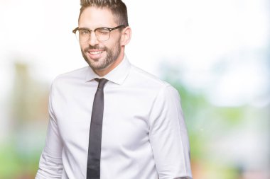 Seksi bir ifadeyle, neşeli ve mutlu yüzünü kameraya bakarak göz kırpıyor izole arka plan üzerinde gözlük takan genç yakışıklı iş adamı.