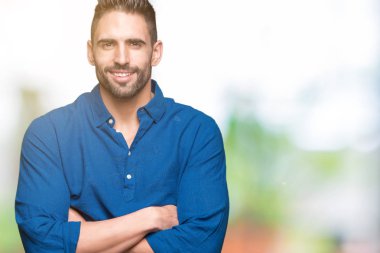 Yakışıklı delikanlı emin çapraz kollar ve çeneme kaldırdı el ile gülümseme ile kameraya bakarak izole arka plan üzerinde. Pozitif düşünce.