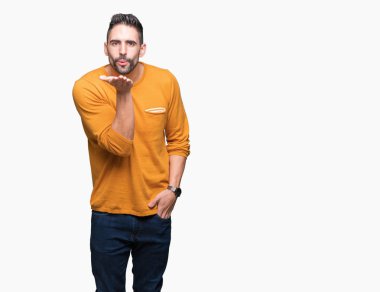 Yakışıklı delikanlı bir öpücük el ile güzel ve seksi olmak hava üfleme kamera bakarak izole arka plan üzerinde. Aşk ifade.