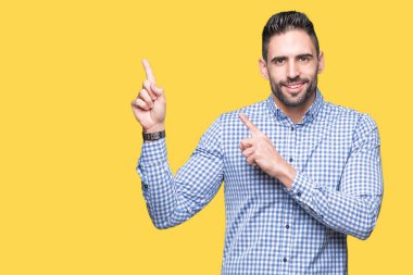 Yakışıklı delikanlı gülümseyen ve iki elleri ve parmakları ile tarafına işaret kamera bakarak izole arka plan üzerinde.