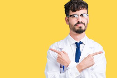 Genç profesyonel bilim adamı giyen beyaz önlük izole üzerinde arka plan için her iki parmak, farklı yönde ile katılmıyorum işaretleme