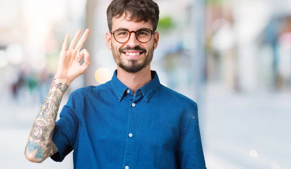 Joven Hombre Guapo Con Gafas Sobre Fondo Aislado Sonriendo Positiva —  Fotos de Stock