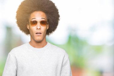 Korkuyor ve şok sürpriz ifade, korku ve heyecan yüz ile güneş gözlüğü takıyor afro saçlı genç Afro-Amerikan adam.
