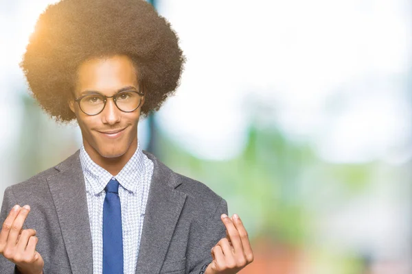 Young african american business man with afro hair wearing glasses Doing money gesture with hand, asking for salary payment, millionaire business