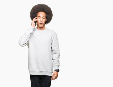 Smartphone bir sürpriz yüz, korkuyor ve heyecanlı korku ifadesi ile şok korkmuş konuşurken afro saçlı genç Afro-Amerikan adam