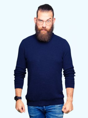 Gözlük ve balıkçı yaka kazak şüpheci ve sinir, papatyanın üzgün sorunu nedeniyle giyen genç sarışın adam. Negatif kişi.