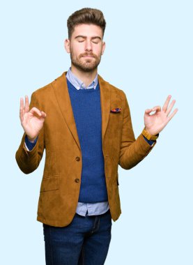 Genç yakışıklı iş adamı rahatla ve gülümseyen gözlerle kapalı parmak jestle meditasyon yapıyor. Yoga kavramı.
