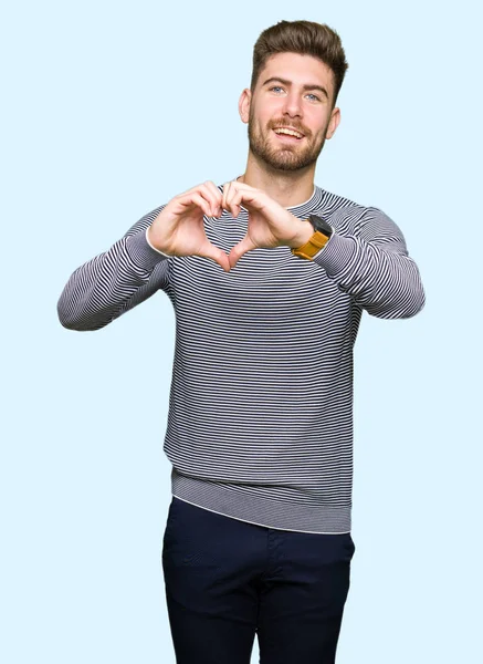 Joven Hombre Guapo Con Rayas Suéter Sonriendo Amor Mostrando Símbolo —  Fotos de Stock