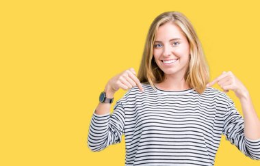 Yüzünde gülümseme ile kendinden emin görünüyorsun, kendini gururlu ve mutlu parmakları ile işaret izole arka plan üzerinde kazak giyen güzel genç kadın çizgili.