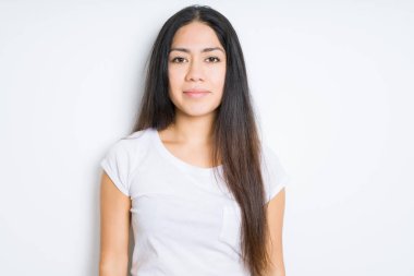 Yüzünde ciddi bir ifade ile izole arka plan güzel esmer kadın. Basit ve doğal kameraya bakıyor.