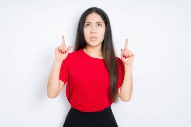 İzole arka plan üzerinde kırmızı t-shirt giyen güzel esmer kadın hayran ve görünümlü ve parmaklar ve yükseltilmiş kollar ile işaret şaşırttı.