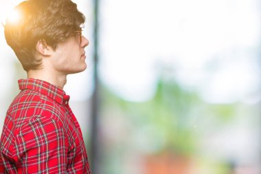 Genç yakışıklı adam gözlük izole arka tarafına, seyir üzerinde dinlenmek doğal yüz emin gülümseme ile pozuyla profili.