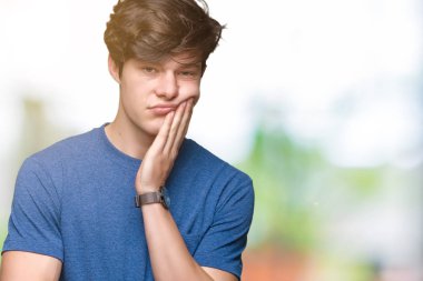 Seyir yorgun ve bıkkın ile depresyon sorun Çapraz kollar ile izole arka plan düşünme üzerinde mavi t-shirt giyen genç yakışıklı adam.