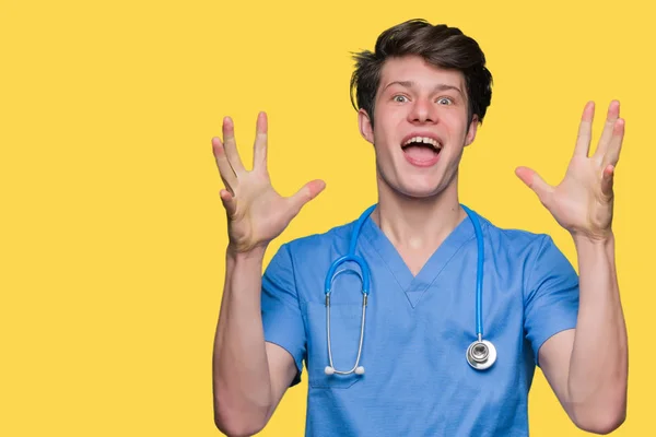 若い医師に医療の制服を着ては狂気を祝う背景を分離し 腕の成功のため驚いて叫んで興奮発生と開いた目 勝者の概念 — ストック写真