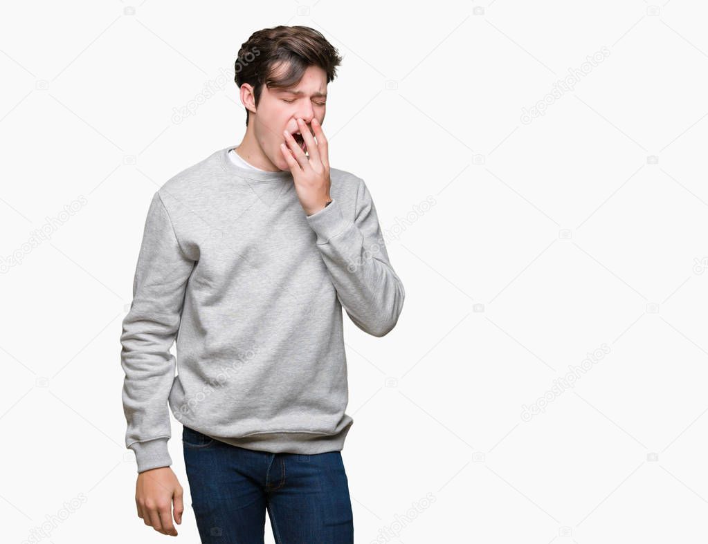 Young handsome sporty man wearing sweatshirt over isolated background bored yawning tired covering mouth with hand. Restless and sleepiness.