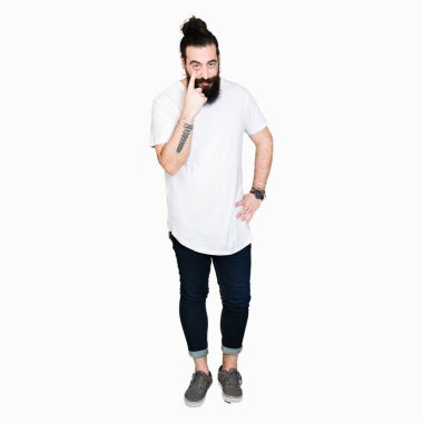 Uzun saç ve sakal casual beyaz t-shirt işaretleme göz izlerken seni jest, şüpheli ifade için giyen genç hipster adamla