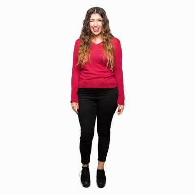 Kırmızı kazaklı seksi bir ifadeyle, neşeli ve mutlu yüzünü kameraya bakarak göz kırpıyor giyen genç güzel kadın.