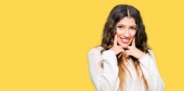 Beyaz kazak giyen genç güzel kadın ile açık ağız gülümseyen, işaret ve neşeli zorla parmak gülümse