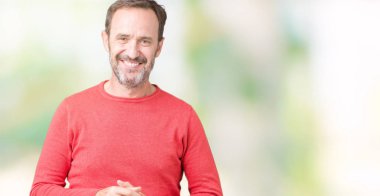 Arka plan eller üzerinde kış kazak giymiş yakışıklı orta yaş ağarmış komuta sizde birlikte izole ve rahat ve neşeli gülümseyen parmak çarpı işareti. Başarı ve iyimser