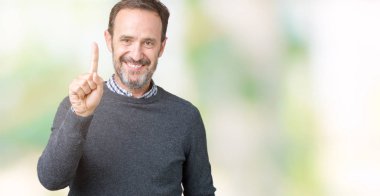 Yakışıklı orta yaş komuta sizde gösterilen ve kendinden emin ve mutlu gülümseyen bir parmak ile işaret eden oktan yukarı izole arka plan üzerinde bir kazak giyiyor.