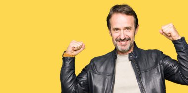 Siyah deri ceket gösteren kol kasları gururlu gülümseyen giyen orta yaş yakışıklı adam. Fitness kavramı.