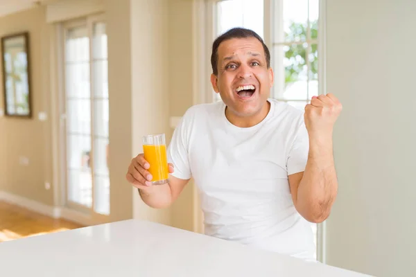 Hombre Mediana Edad Bebiendo Vaso Jugo Naranja Casa Gritando Orgulloso — Foto de Stock