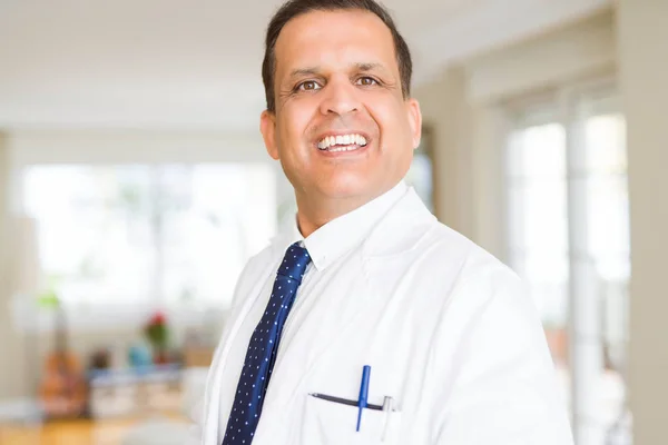 Hombre de mediana edad vistiendo un abrigo médico blanco y sonriendo — Foto de Stock