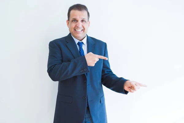 Hombre de negocios de mediana edad sonriendo y señalando hacia el costado — Foto de Stock