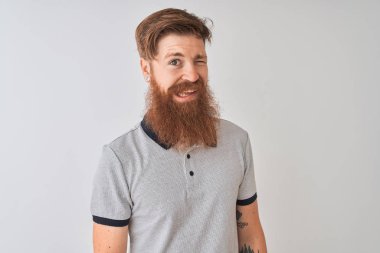 Seksi ifade, neşeli ve mutlu yüz ile kamera bakarak izole beyaz arka plan üzerine gri Polo ayakta giyen genç Redhead İrlandalı adam.