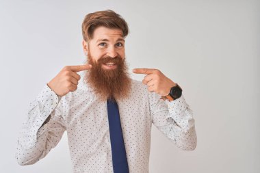 Genç Redhead İrlandalı işadamı ayakta izole beyaz arka plan gülümseyen neşeli gösteren ve parmaklar diş ve ağız ile işaret. Diş Sağlığı konsepti.