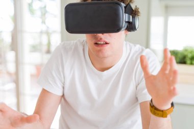 Genç adam eğleniyor evde sanal gerçeklik gözlüklü