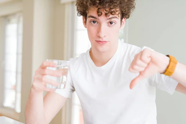 Młody Człowiek Pije Szklankę Wody Domu Gniewną Twarzą Negatywnym Znakiem — Zdjęcie stockowe