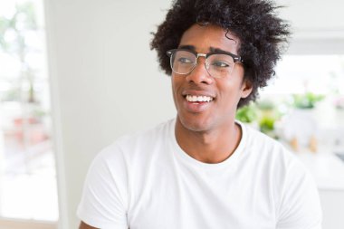 Afrika kökenli Amerikalı adam gözlüklü görünümlü yan ve dik dik bakma uzağa düşünce gülümseyen.