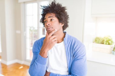 Afrika kökenli Amerikalı adam evde çene düşünme hakkında soru, dalgın ifade üzerine el ile. Düşünceli yüzüyle gülümsüyor. Şüphe kavramı.