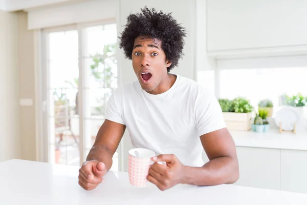 Afričan Americký Muž Afro Pije Šálek Kávy Vystrašený Šoku Překvapením — Stock fotografie