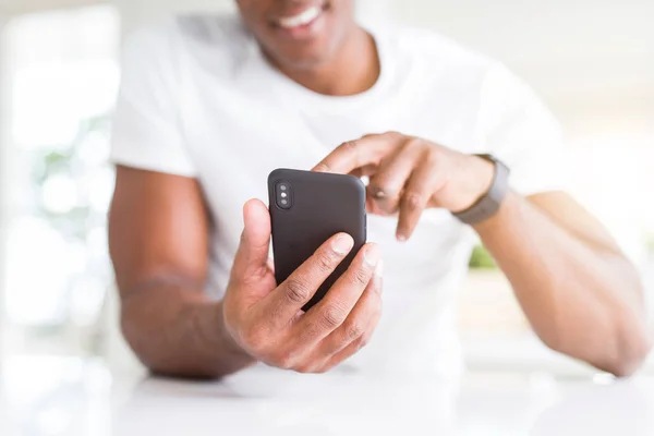 Close up of african american man hands using smartphone and smil — Stock Photo, Image